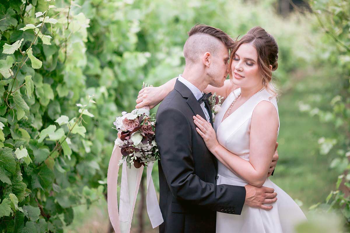 Wedding-couple-embrace-in-wild-vineyard