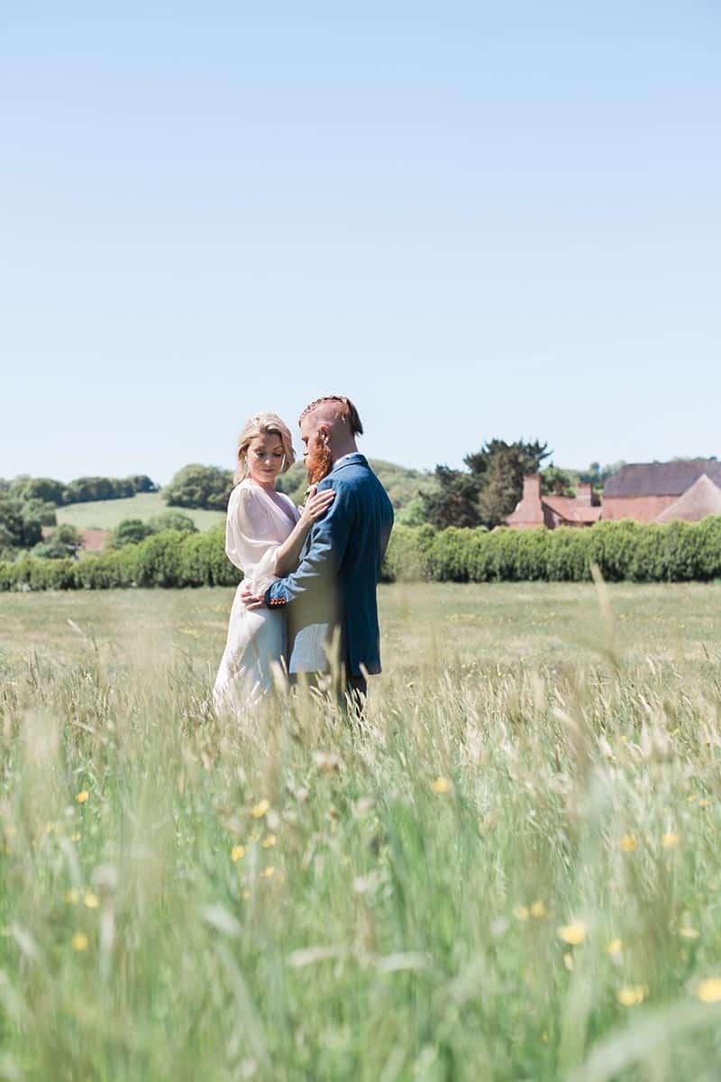 Intimate-wedding-venue-–-a-couple-standing-embraced-in-the-wildflower-meadow
