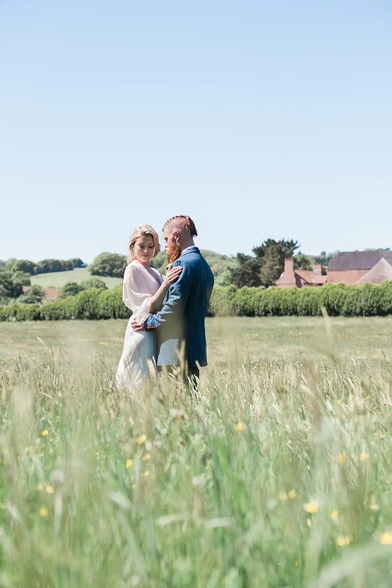 Intimate wedding venue - a couple standing embraced in the wildflower meadow