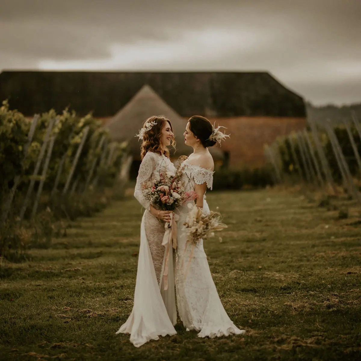 Same sex wedding venue same sex couple embracing in front of rustic barn